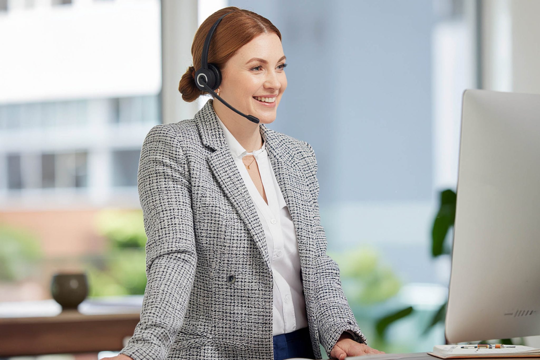 Mood music in sales calls – confident caller standing and speaking with a relaxed, open tone