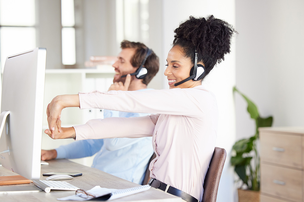 posture for telemarketing calls highlighted by female call centre agent stretching